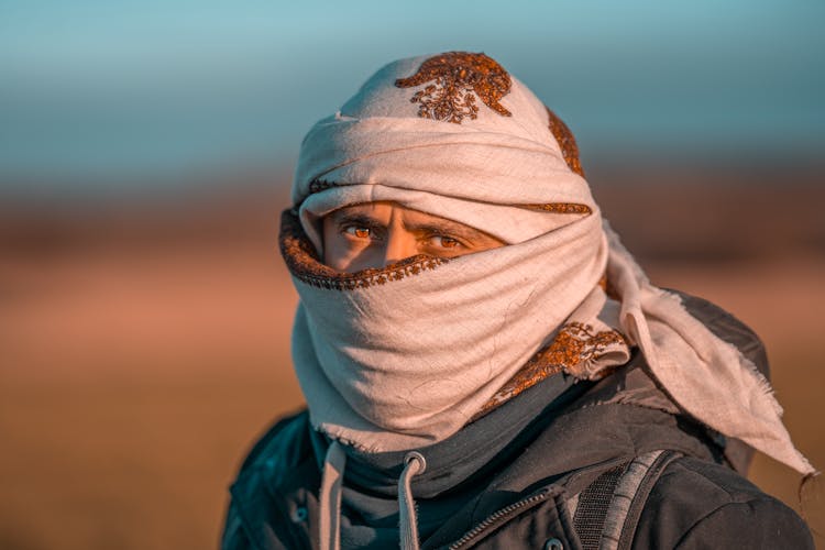 Arab Man In Headscarf Standing In Desert