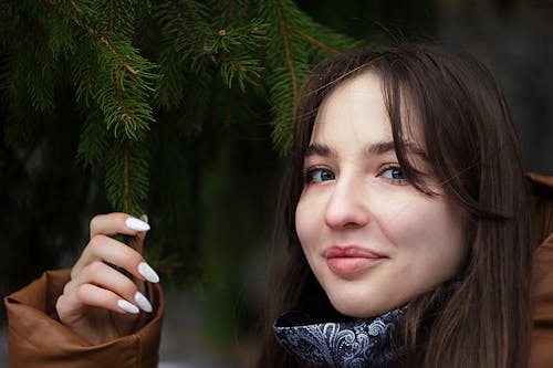 A Pretty Woman Holding Pine Leaves