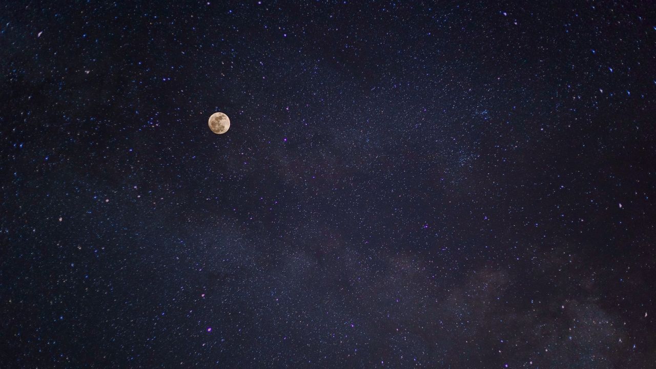 a breathtaking view of the full moon against a starry night sky with t