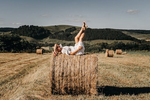 Woman resting on haystack in countryside