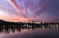 在充满活力的天空下，布拉格城堡迷人的暮光景色倒映在伏尔塔瓦河上