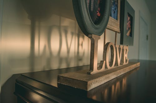 Коричневая деревянная любовь, свободно стоящее письмо на черной деревянной поверхности
