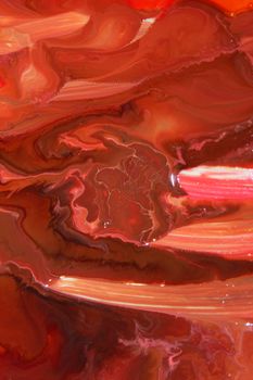 Close-up of vibrant red and orange liquid paint creating abstract swirls.