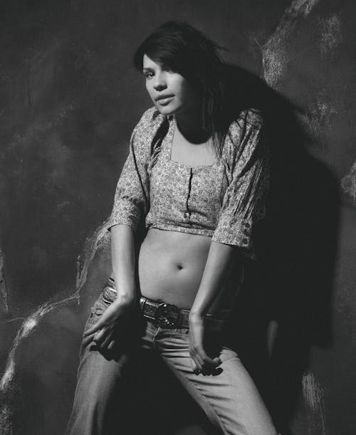 A Grayscale Photo of a Woman Modeling in a Trendy Outfit
