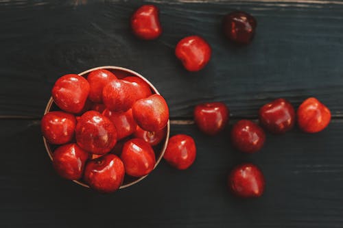 Ripe healthy acerola cherries scattered on table