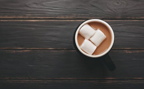 Free From above mug of delicious aromatic cocoa with marshmallows served on wooden table Stock Photo