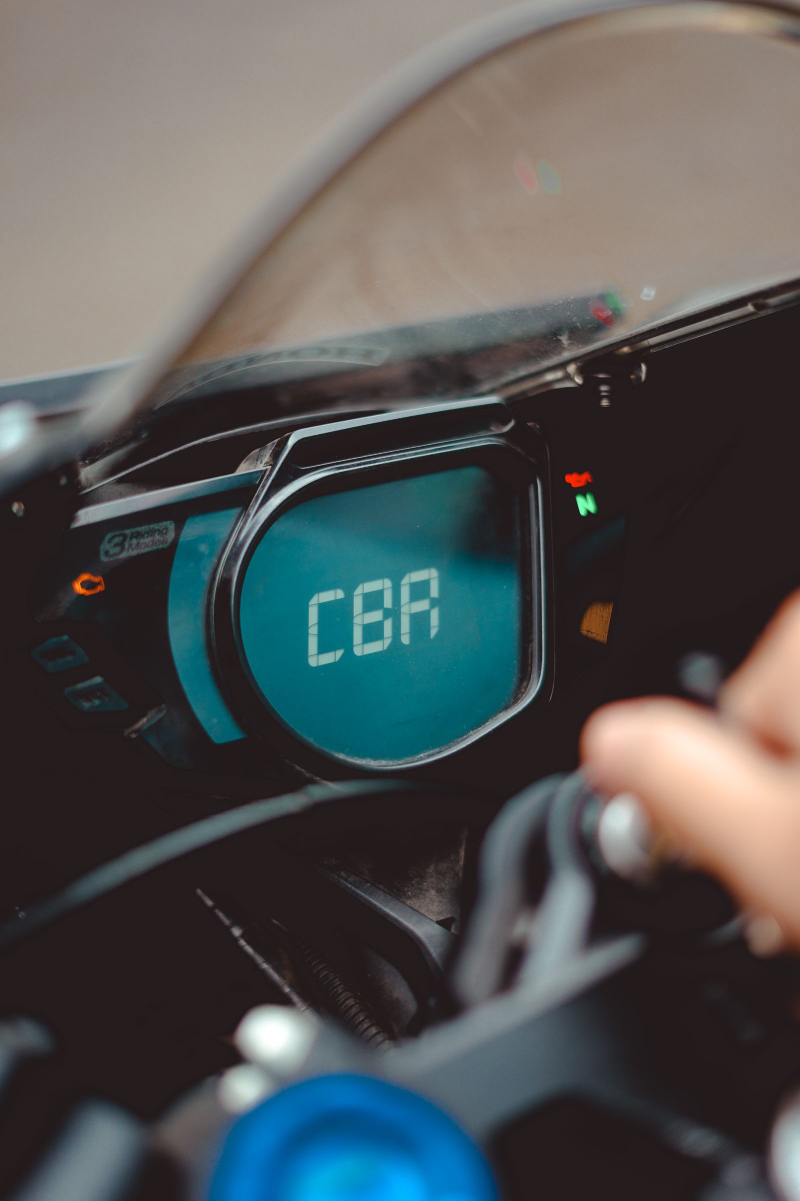 Tableau de bord électronique d'une moto affichant la vitesse et plusieurs voyants d'alerte