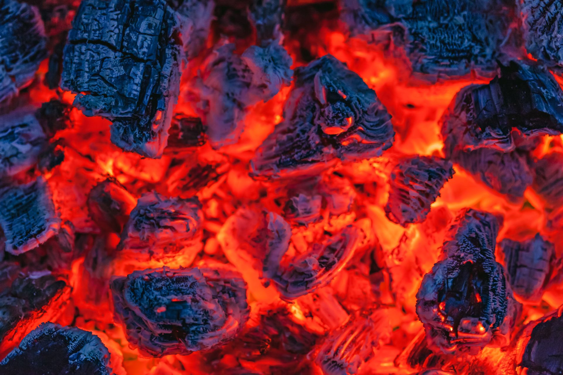 From above of many hot burning coals placed in bonfire in evening time