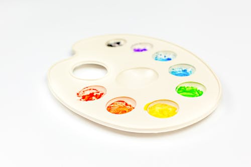 Palette with colorful paints on white background