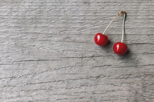 Free Overhead view of tasty fresh cherries with shiny peel and peduncles on rough wooden surface Stock Photo