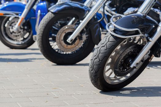 Modern motorbikes parked on pavement in town