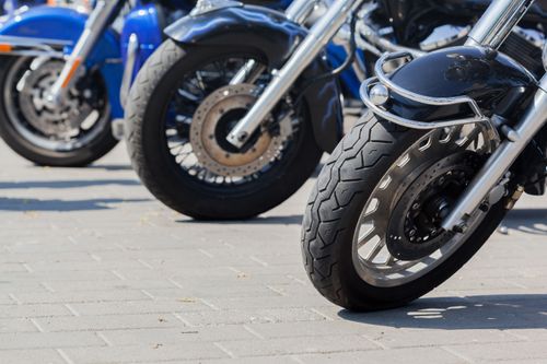 Free Row of contemporary motorcycles parked on tiled walkway with shadows in city on sunny day Stock Photo