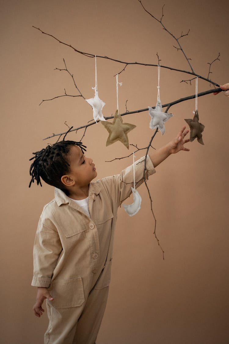 Curios Black Boy Reaching Hand To Decorative Star