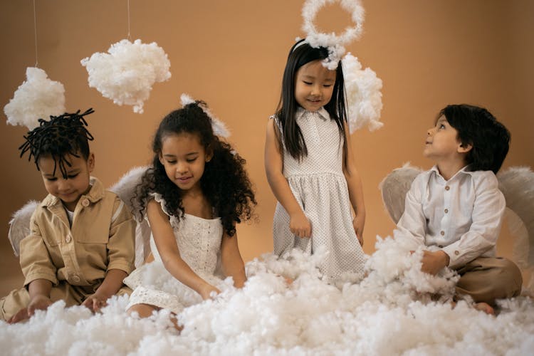 Content Diverse Children In Angel Costumes Playing With Cotton Wool