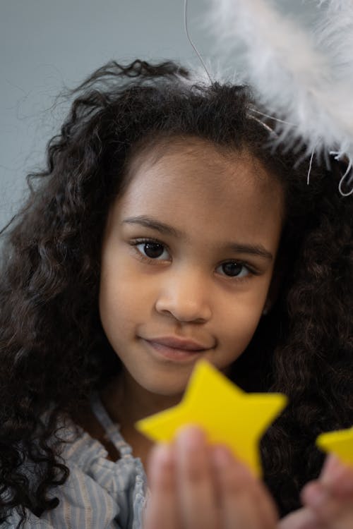 Cute black girl with nimbus and star in hand