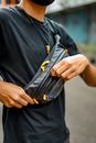 Person in Black Long Sleeve Shirt Holding Black Leather Sling Bag