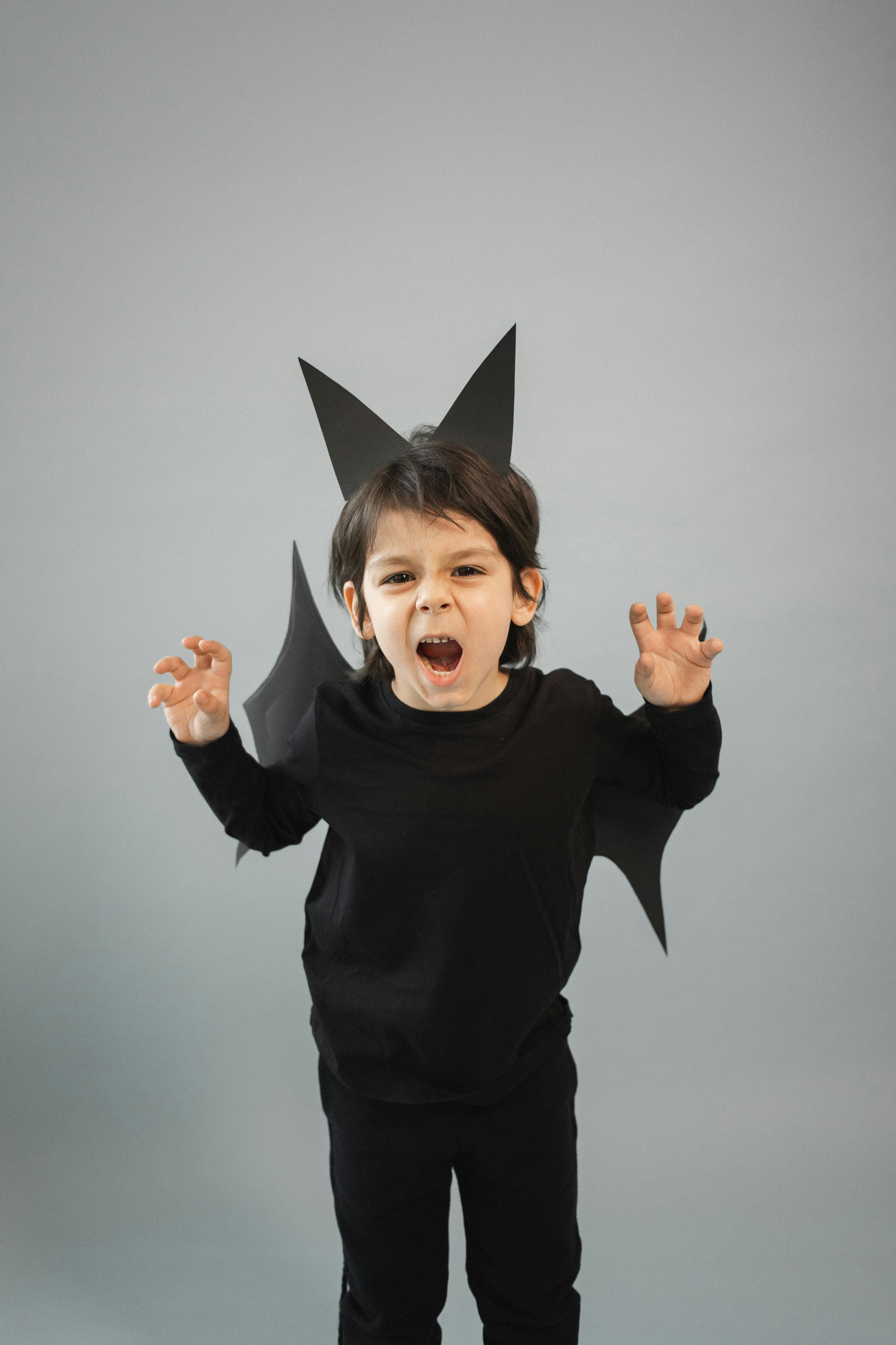 irritated boy in black bat costume