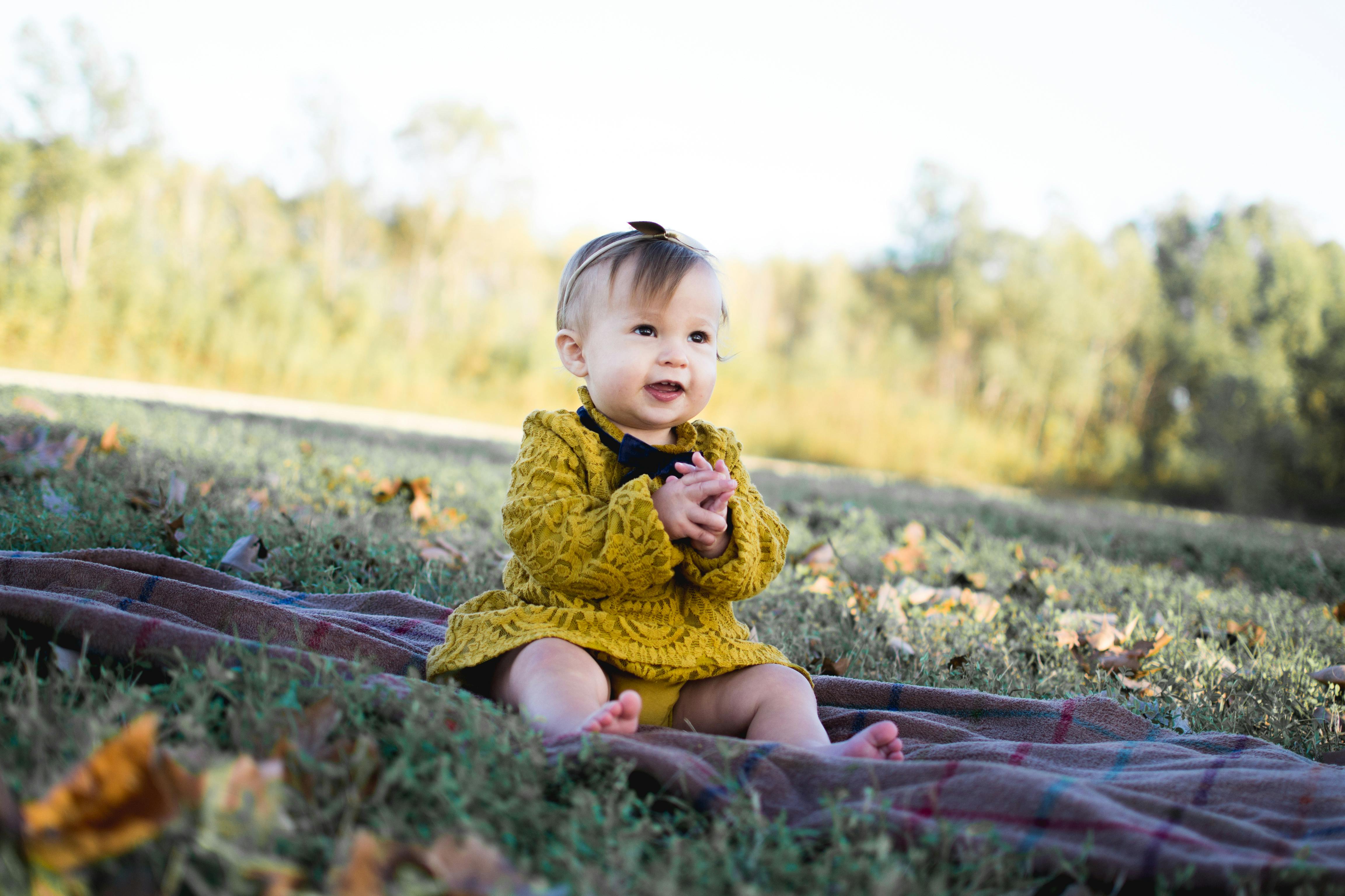 Baby Wearing Yellow Crochet Long Sleeve Dress Sitting on Brown Textile