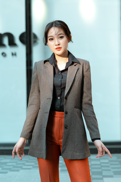 Free Confident woman modeling fashionable blazer and pants in an outdoor setting. Stock Photo