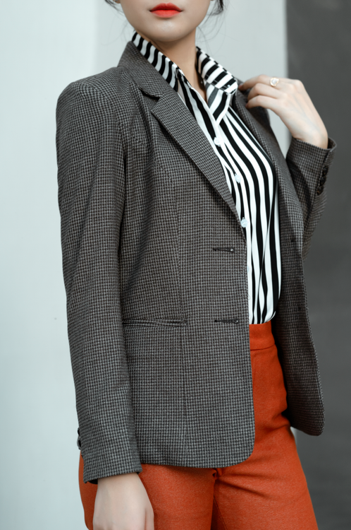 Woman in a grey plaid blazer with a black top