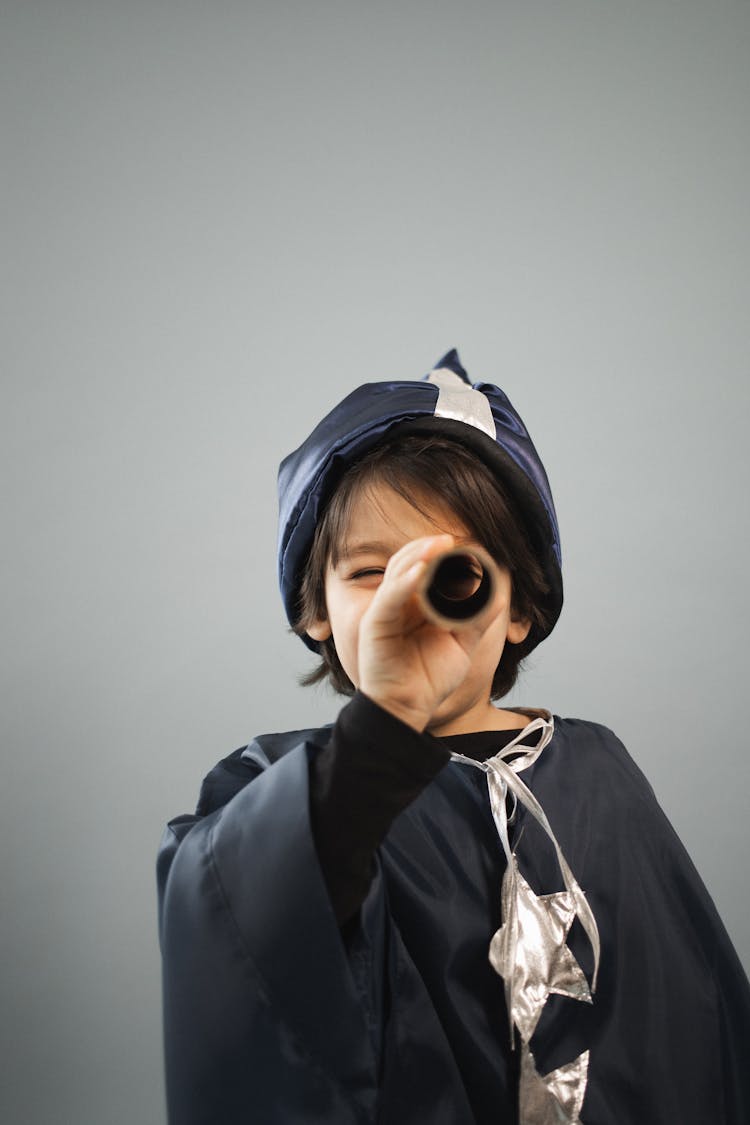 Boy In Astrologer Costume Looking Through Spyglass