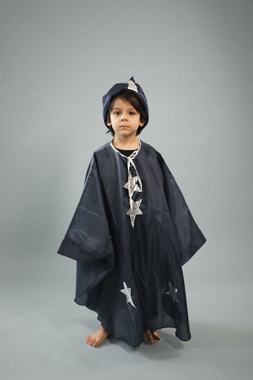 Free Small boy wearing magician costume standing in studio Stock Photo