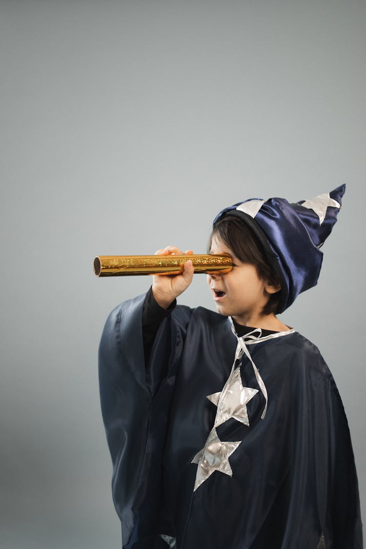 Amazed Boy Wearing Magician Cape Looking Through Kaleidoscope Tube