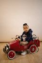 Full body of amazed African American boy wearing cool stylish casual clothes sitting in old fashioned velomobile