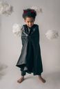 Full body of cute barefoot African American boy wearing devil costume with horns looking at camera on white background in studio