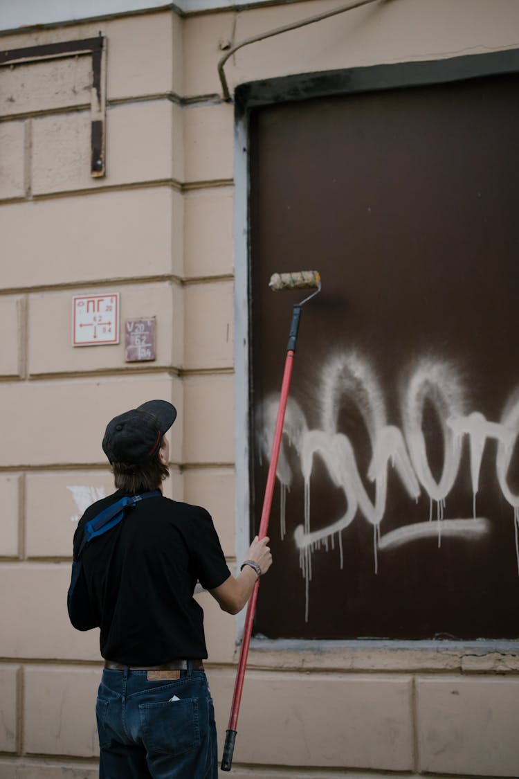 A Man Painting A Wall