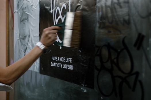 A close-up of street art poster application, featuring graffiti and urban style.