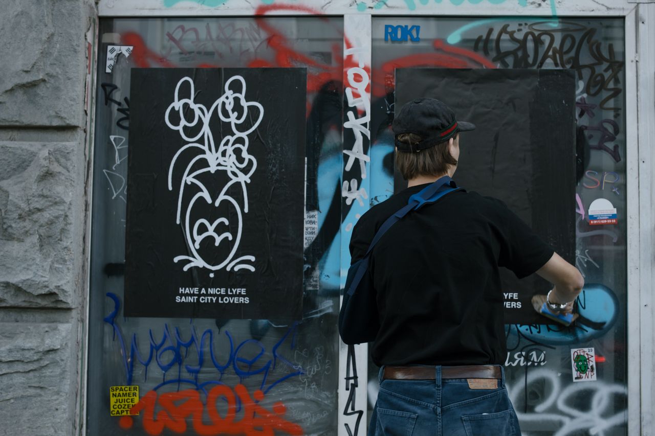 person creating street art on a graffiti covered wall showcasing urban