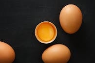 Top view of whole and half of fresh chicken eggs with yolk representing uniqueness concept
