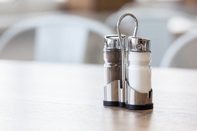 Salt And Pepper Shakers In Holder On Table