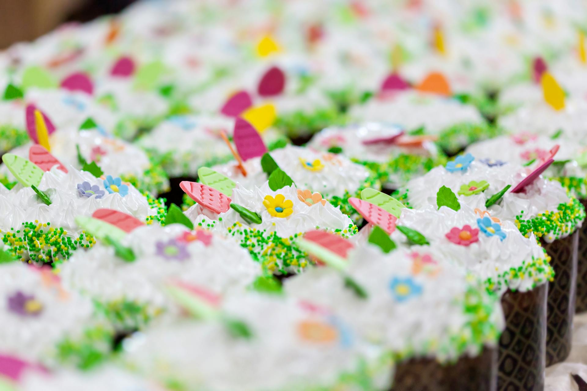 Delicious desserts with sugar paste egg and flower decor on whipped meringue cream in confectionery