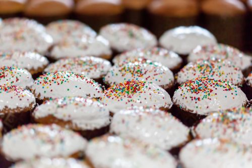 Free Tasty sweet Easter cakes with cream and sprinkles placed in rows in daylight Stock Photo