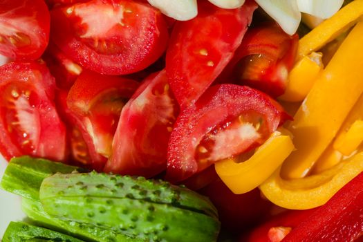 From above of fresh ripe tomatoes and cucumbers placed near yellow peppers for healthy salad