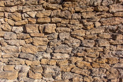 Free Abstract background of rough old stone wall of aged settlement illuminated by sunlight Stock Photo