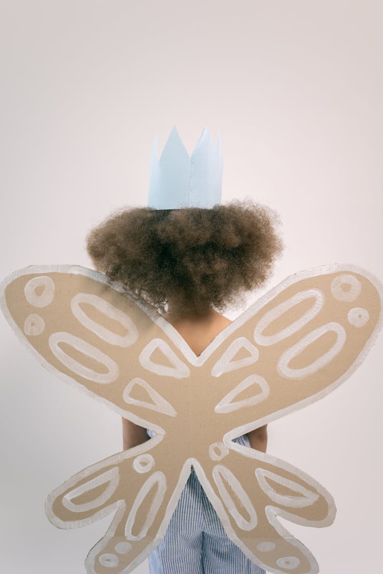 Kid Wearing Crown And Cardboard Wings With White Pattern