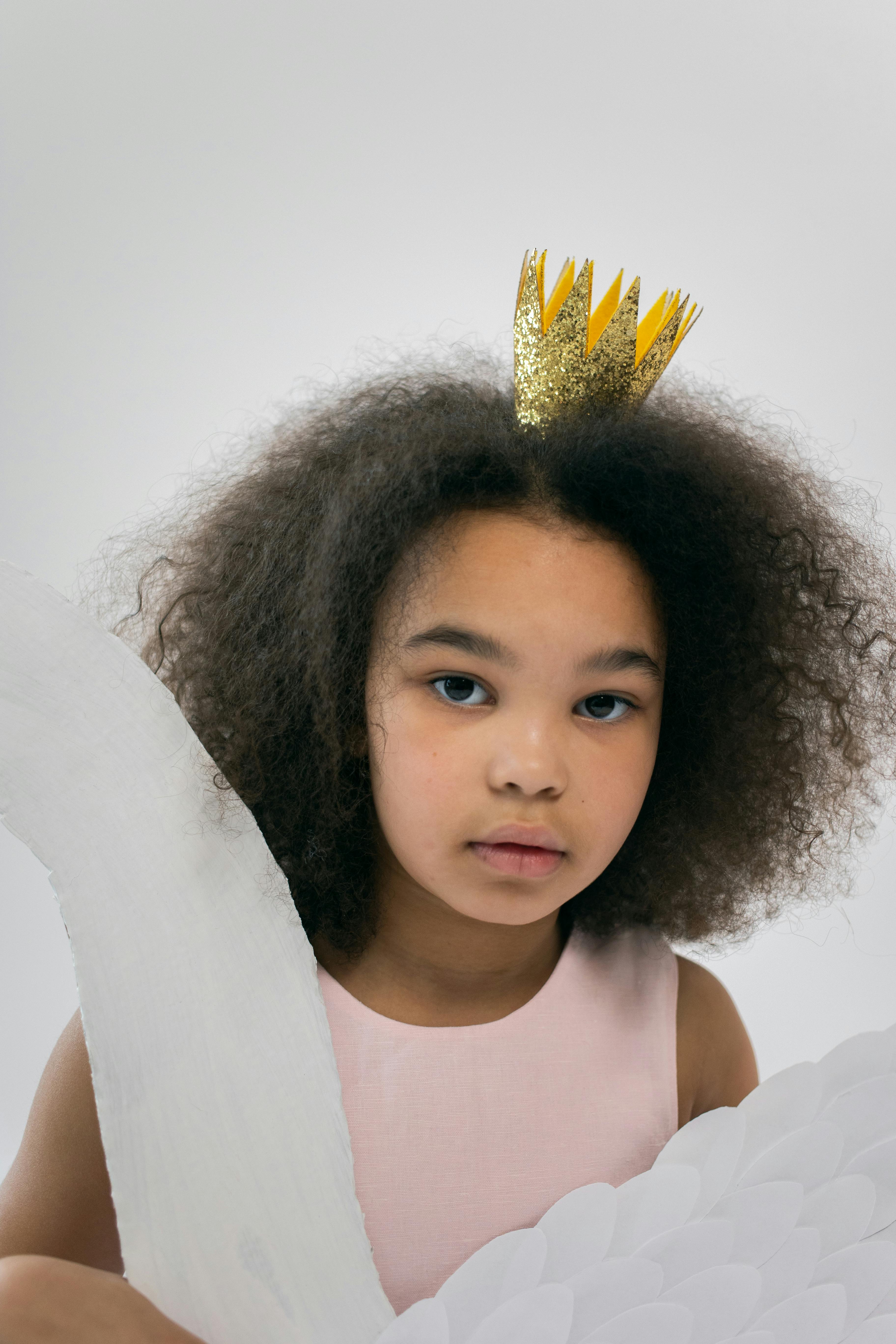 pretty girl with crown holding paper wings