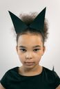 Charming African American girl with Afro wearing black costume and handmade ears looking at camera on white background