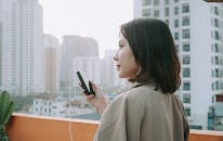 Woman in Beige Blazer Holding a Small Cellphone