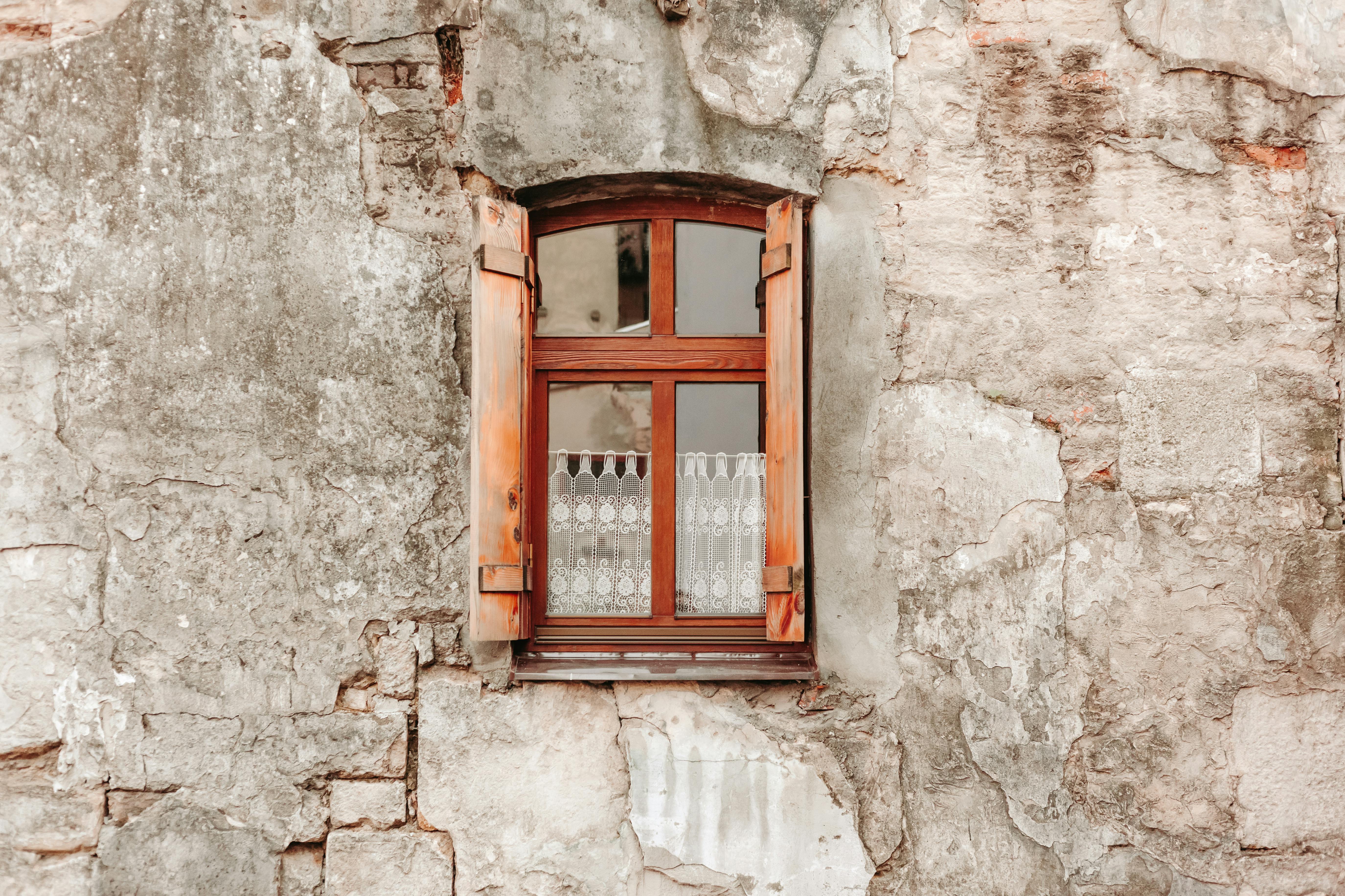 Brown Wooden Framed Glass Window in a Shabby Stone Wall