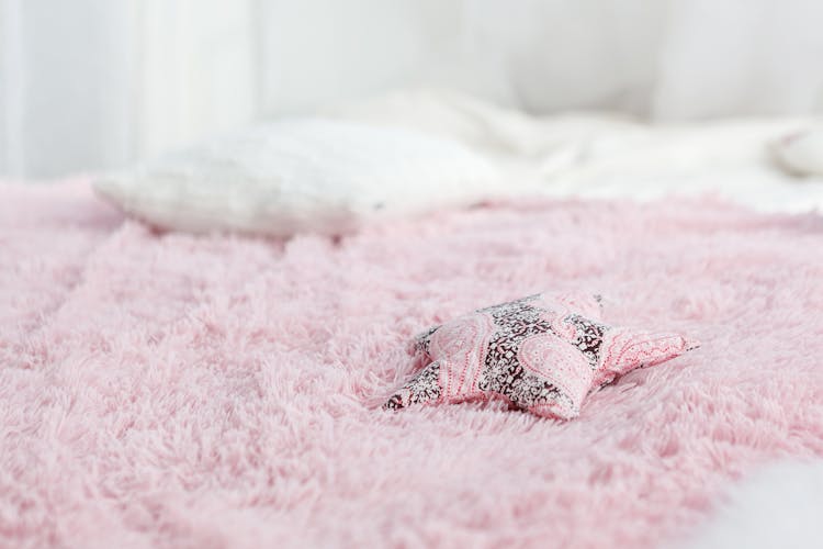 A Star Shaped Pillow On A Fuzzy Blanket