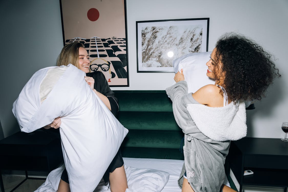 Two Young Women Having Fun Doing Pillow Fight