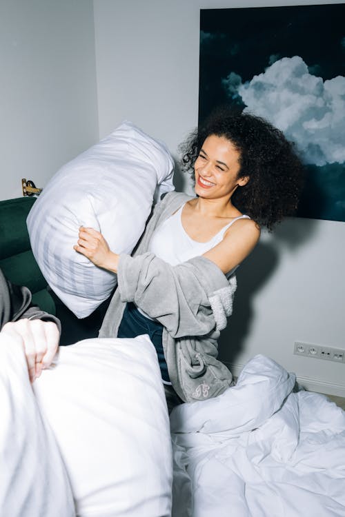 Young Woman Having Fun While Doing Pillow Fight