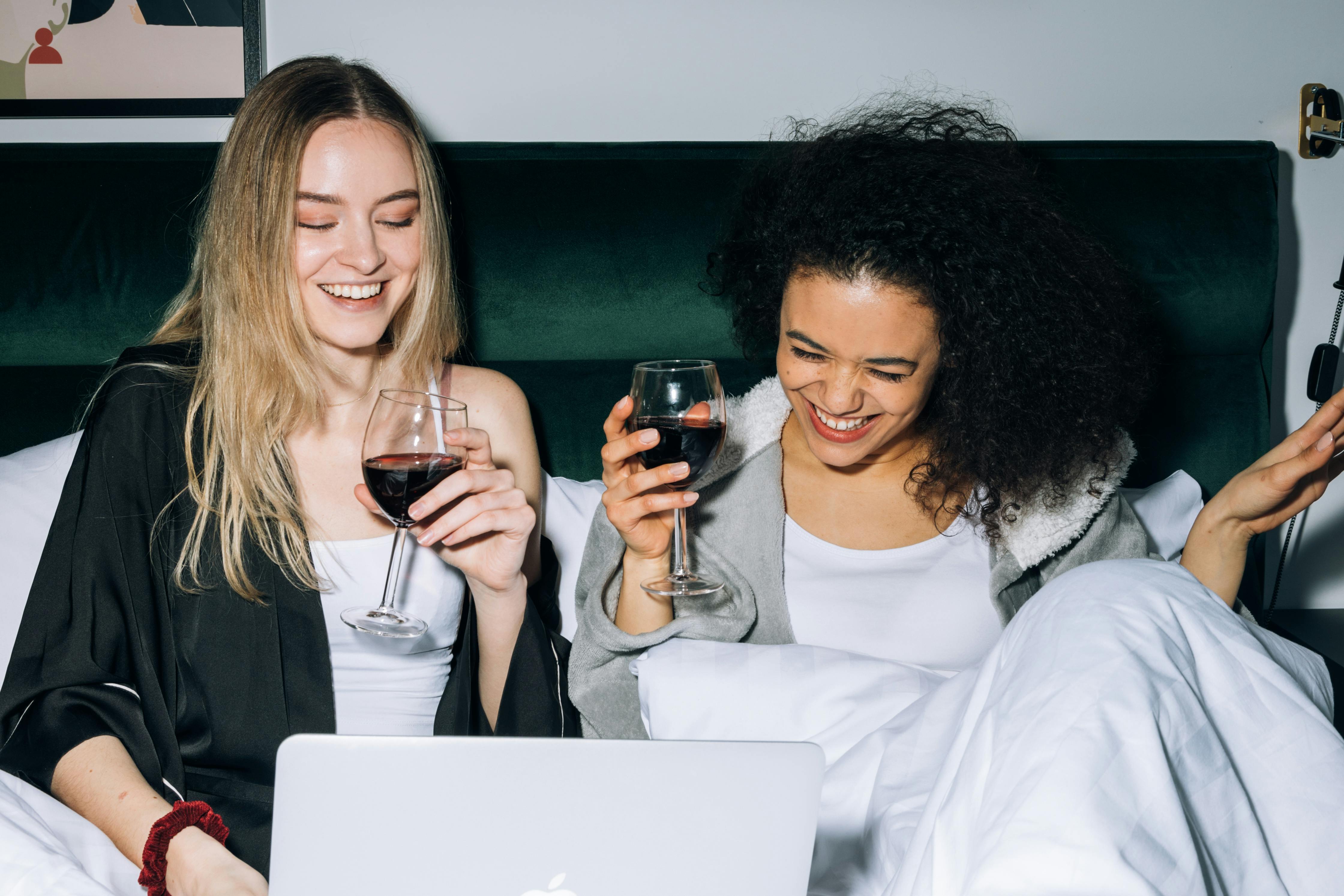 two young women having fun while looking at a laptop