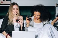 Two Young Women Having Fun While Looking at a Laptop