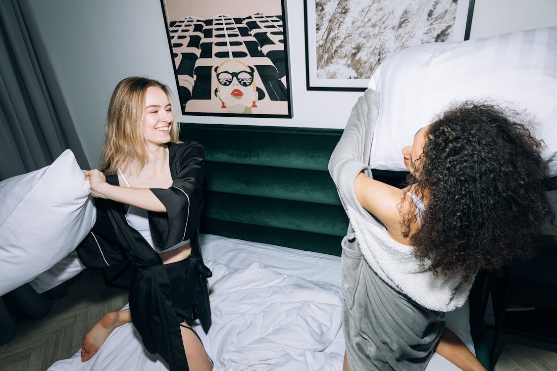 Two Young Women Having Fun Doing Pillow Fight