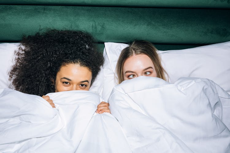 Two Young Girls Lying On White Bed